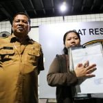 Nila Handiarti (kanan) didampingi Kepala Disperinaker Surabaya Achmad Zaini usai melakukan pelaporan di Polres Pelabuhan Tanjung Perak, Senin (14/4/2025).