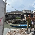 Personel Satpol PP membongkar bangunan yang berdiri di bantaran Sungai Kalianak, Kecamatan Asemrowo Surabaya, Kamis (15/5/2025). (dok. Satpol PP Surabaya)
