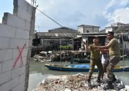 Personel Satpol PP membongkar bangunan yang berdiri di bantaran Sungai Kalianak, Kecamatan Asemrowo Surabaya, Kamis (15/5/2025). (dok. Satpol PP Surabaya)
