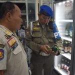 Satpol PP Surabaya saat melaksanakan pengawasan dan penindakan terhadap peredaran miras ilegal pada Sabtu (21/6/2025) malam.