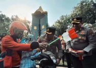 Pembagian bendera merah putih kepada pengendara berlangsung di Jalan Polisi Istimewa, Surabaya, Rabu (13/8/2025). (Polrestabes Surabaya)